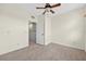 Bedroom with neutral carpet, ceiling fan, and open doorway to the hallway with stairs at 13228 Daniels Landing Cir, Winter Garden, FL 34787