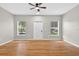Well-lit living room with wood-look flooring, ceiling fan, and view of the front entrance at 13228 Daniels Landing Cir, Winter Garden, FL 34787