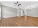 Open-concept living room with wood-look flooring, ceiling fan, and stairs to the upper level at 13228 Daniels Landing Cir, Winter Garden, FL 34787