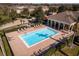 An aerial view of the community pool featuring lounge chairs, an elegant pool cabana, and mature landscaping throughout at 13228 Daniels Landing Cir, Winter Garden, FL 34787