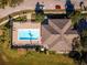 An aerial view of the community pool featuring lounge chairs, an elegant pool cabana, and lush landscaping throughout at 13228 Daniels Landing Cir, Winter Garden, FL 34787