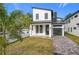 Modern two-story home with a white exterior, black accents, and a paver driveway at 233 E Harding St, Orlando, FL 32806