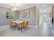 Elegant dining room with modern light fixture and art at 571 Drop Shot Dr, Davenport, FL 33896