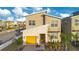 Two-story house with yellow garage door and landscaped yard at 571 Drop Shot Dr, Davenport, FL 33896