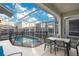 Enjoy this relaxing screened pool and spa with outdoor dining area at 571 Drop Shot Dr, Davenport, FL 33896