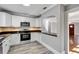 Modern kitchen with white cabinets, stainless steel appliances, and a breakfast bar at 728 Palm Dr, Orlando, FL 32803