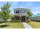 Charming two-story home featuring gray siding, brick accents, and a welcoming covered front porch at 813 S Locust Ave, Sanford, FL 32771