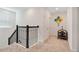 Upstairs hallway with carpeted floor and black railing at 1179 Kingsbarn St, Davenport, FL 33896