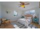 Cozy bedroom with a ceiling fan, two windows and vibrant decor at 136 Reef Rd, South Daytona, FL 32119