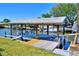 Waterfront dock with a boat lift and a boat parked on the lift in a neighborhood at 136 Reef Rd, South Daytona, FL 32119