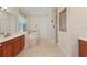 Spacious bathroom with travertine tile, soaking tub, vanity, and glass-enclosed shower at 1912 Westover Reserve Blvd, Windermere, FL 34786