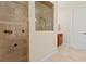 Tiled shower with glass partition is shown alongside a vanity area with wood cabinet at 1912 Westover Reserve Blvd, Windermere, FL 34786