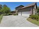 Long driveway leads to a two-car garage, complemented by landscaped bushes at 1912 Westover Reserve Blvd, Windermere, FL 34786