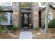 Elegant front door with stone accents and decorative glass, framed by lush landscaping at 1912 Westover Reserve Blvd, Windermere, FL 34786
