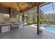 Inviting outdoor kitchen with tile backsplash overlooking the pool and greenery at 1912 Westover Reserve Blvd, Windermere, FL 34786