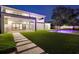 Night view of backyard with a pool, outdoor kitchen, manicured lawn, and modern architectural design at 2161 Sharon Rd, Winter Park, FL 32789