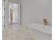 Bright bathroom showcasing a freestanding tub with marble-look tile flooring and modern fixtures at 2161 Sharon Rd, Winter Park, FL 32789