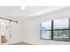 Bright bedroom with a barn door leading to the bathroom and a view of the backyard through the window at 2161 Sharon Rd, Winter Park, FL 32789