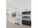 Modern kitchen with white cabinets, stainless steel appliances, quartz countertops, and stylish black hardware at 2161 Sharon Rd, Winter Park, FL 32789