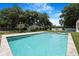 A serene backyard featuring a sparkling pool, lush lawn, and well-maintained landscaping, perfect for relaxation at 2161 Sharon Rd, Winter Park, FL 32789