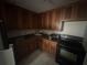 View of the kitchen with black appliances and dark wood cabinets at 4008 Versailles Dr # 4008C, Orlando, FL 32808