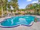 Community swimming pool surrounded by lush landscaping and trees at 4008 Versailles Dr # 4008C, Orlando, FL 32808