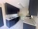 This kitchen features dark cabinets, stainless steel sink, and white countertops, with light tile floors at 4121 Dijon Dr # 4121H, Orlando, FL 32808