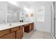 Spacious bathroom featuring double vanity sinks, a large mirror, and a glass-enclosed shower at 4501 Monado Dr, Kissimmee, FL 34746