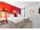 Comfortable bedroom with twin beds, neutral carpet, and a red accent wall with jungle theme at 4501 Monado Dr, Kissimmee, FL 34746