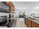 Contemporary kitchen with granite countertops, black appliances, and an adjacent dining area with natural light at 4501 Monado Dr, Kissimmee, FL 34746
