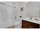 Clean bathroom with wood vanity, white countertops, a seashell art piece, and a shower-tub combo at 4571 Cabello Loop, Kissimmee, FL 34746