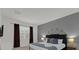 Well-lit bedroom with a gray accent wall, modern lamps, and a comfortable bed with decorative pillows at 4571 Cabello Loop, Kissimmee, FL 34746