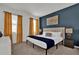 Comfortable bedroom featuring a blue accent wall, beige carpet, and modern furnishings at 4571 Cabello Loop, Kissimmee, FL 34746