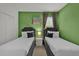 Inviting green bedroom featuring two beds, each dressed with plush pillows and black accents at 4571 Cabello Loop, Kissimmee, FL 34746