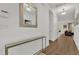 Bright entryway showcasing modern console table and mirror, leading into a living area with hardwood floors and neutral décor at 4571 Cabello Loop, Kissimmee, FL 34746