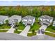 An aerial view of three homes showcasing manicured lawns and private driveways in a lush, green, well-maintained neighborhood at 4571 Cabello Loop, Kissimmee, FL 34746