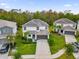 Aerial shot of a two-story white house with well-manicured lawn, mature trees, and a driveway with a two-car garage at 4571 Cabello Loop, Kissimmee, FL 34746