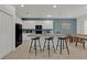 Open-concept kitchen with a large island, granite countertops, white cabinets, and a dining area with modern bar stools at 4571 Cabello Loop, Kissimmee, FL 34746