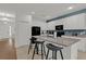 Bright kitchen with granite countertops, modern appliances, white cabinets, tile flooring, and a breakfast bar with stylish stools at 4571 Cabello Loop, Kissimmee, FL 34746