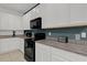 A well-equipped kitchen with white cabinets, granite countertops, and stainless steel appliances at 4571 Cabello Loop, Kissimmee, FL 34746