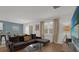Bright living room with hardwood floors, comfortable seating, and a sliding glass door. Dining area visible in background at 4571 Cabello Loop, Kissimmee, FL 34746