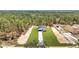 A home and expansive yard are surrounded by lush trees in this aerial shot at 12220 Sw 76Th Ln, Dunnellon, FL 34432