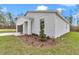 Landscaped front yard with vibrant greenery accentuates the modern home's crisp, white facade at 12220 Sw 76Th Ln, Dunnellon, FL 34432
