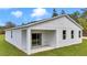 Covered porch exterior view of the home with a sliding glass door and well-kept lawn at 12220 Sw 76Th Ln, Dunnellon, FL 34432