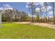 Spacious backyard featuring lush green grass and a wooded area, perfect for outdoor activities at 12386 Sw 89Th St, Dunnellon, FL 34432