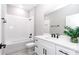 Modern bathroom features a white vanity, a large mirror, and a shower-tub combo with elegant fixtures at 12386 Sw 89Th St, Dunnellon, FL 34432
