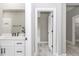 Bathroom featuring a double vanity, a mirror, neutral wall color, and a door with black hardware at 12386 Sw 89Th St, Dunnellon, FL 34432