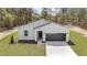 Beautiful exterior elevation of a modern, light and airy home with a well-manicured lawn and landscaping at 12386 Sw 89Th St, Dunnellon, FL 34432