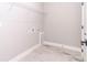 Bright laundry room featuring modern tile floor, white walls, and metal storage shelves at 12386 Sw 89Th St, Dunnellon, FL 34432