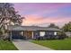 Charming single-story home featuring a quaint front porch, lovely landscaping, and attached carport at 15 Volusia Dr, Debary, FL 32713